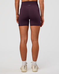 Woman wearing Fusion V-Contour Ultra High-Rise 4” Short Pockets - Midnight Plum | Model:Emelia | Size:S