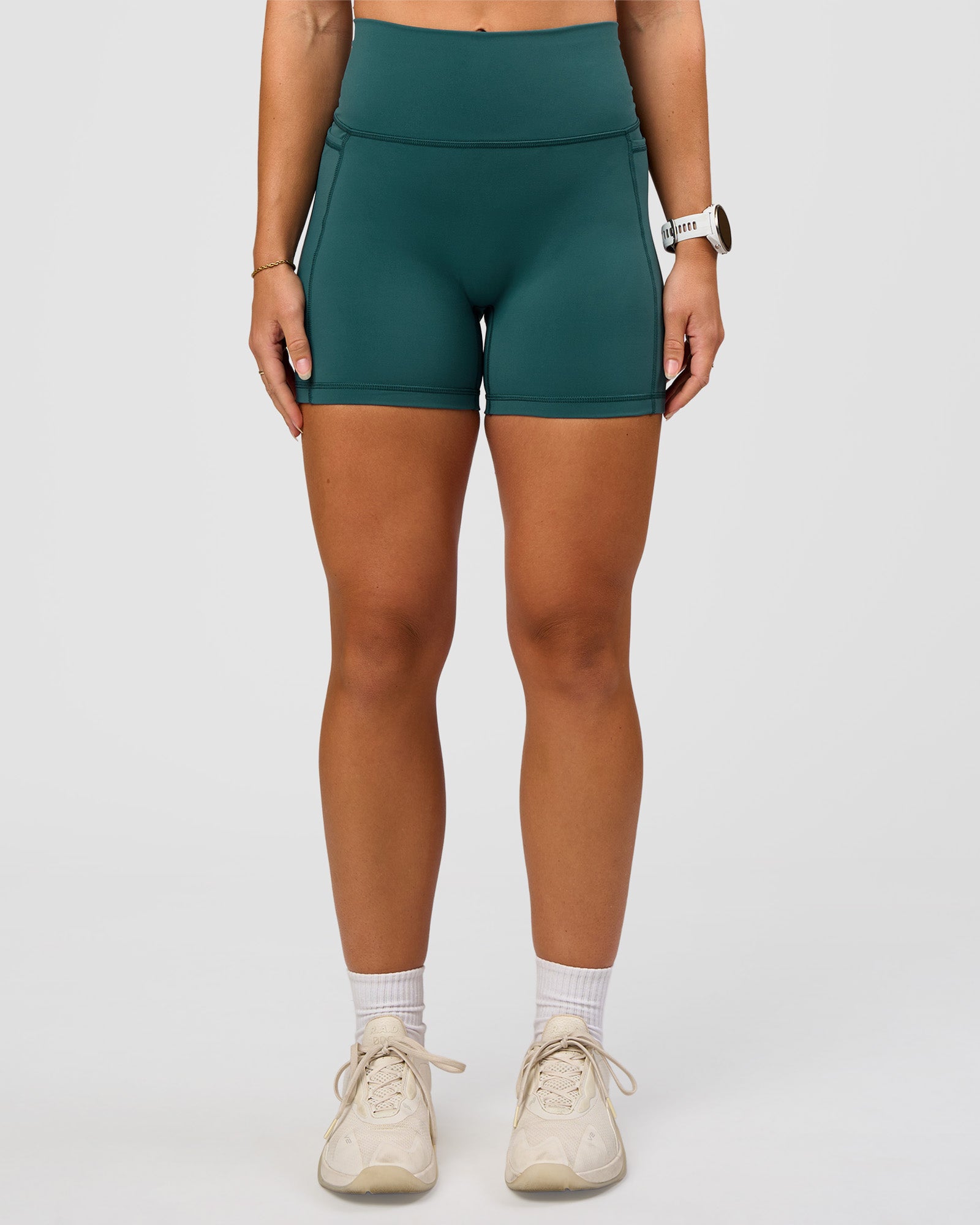 Woman wearing Fusion V-Contour Ultra High-Rise 4” Short Pockets - Transformative Teal | Model:Summer | Size:S