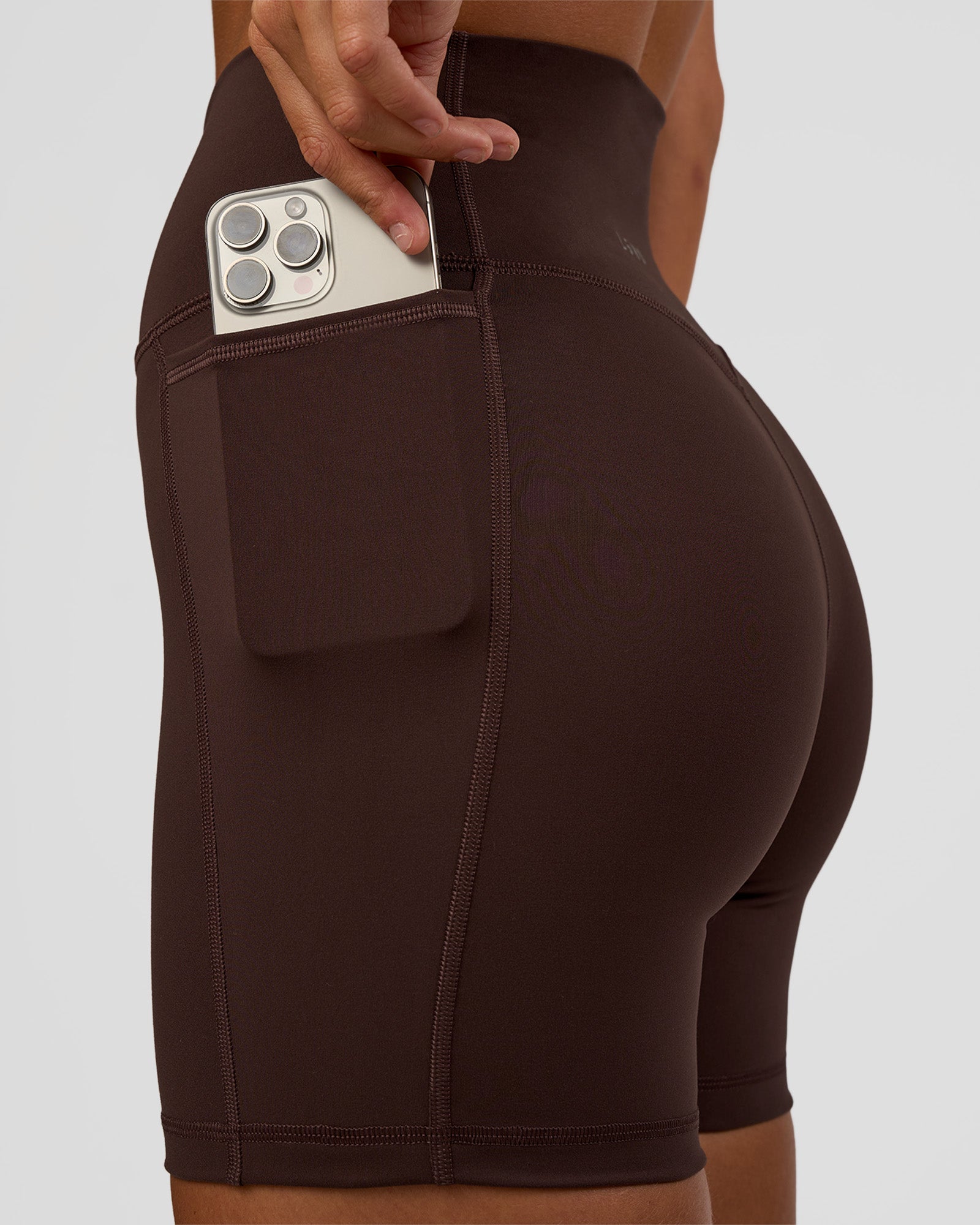 Woman wearing Fusion V-Contour Ultra High-Rise 6" Short Pockets - Hot Chocolate | Model:Amity | Size:S