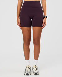 Woman wearing Fusion V-Contour Ultra High-Rise 6" Short Pockets - Midnight Plum | Model:Rhiley | Size:S