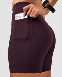 Woman wearing Fusion V-Contour Ultra High-Rise 6" Short Pockets - Midnight Plum | Model:Rhiley | Size:S