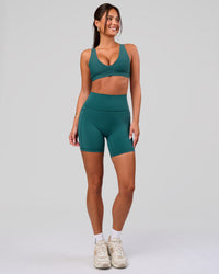 Woman wearing Fusion V-Contour Ultra High-Rise 6" Short Pockets - Transformative Teal | Model:Bianca | Size:S