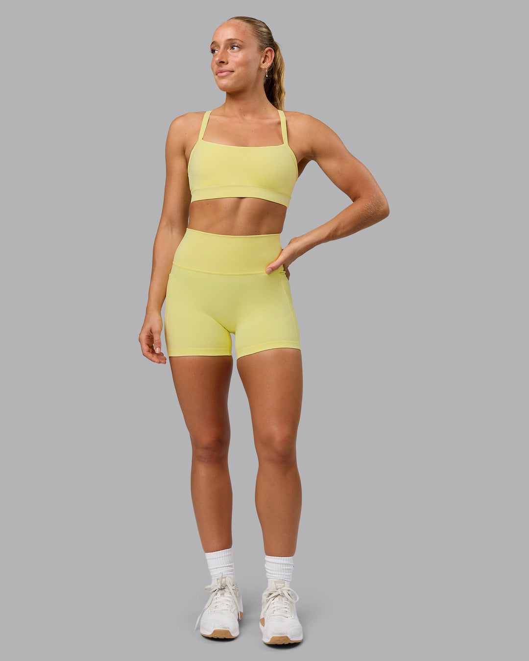 Woman wearing Fusion Ultra High-Rise 4" Short Pockets - Lemon Fizz | Model:Shalem | Size:S