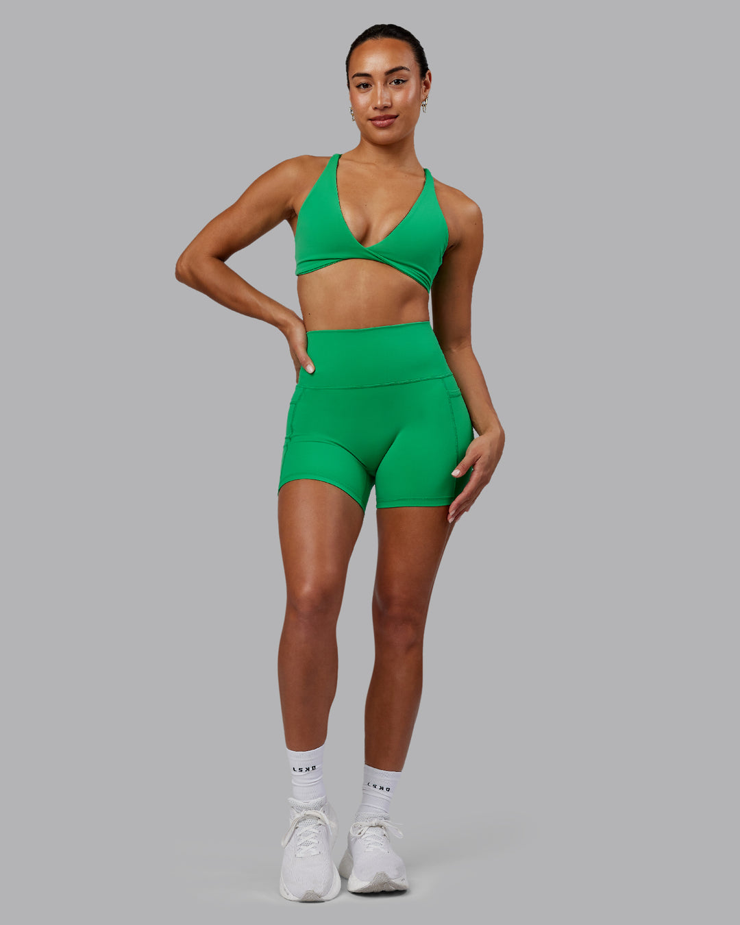 Woman wearing Fusion Ultra High-Rise 4&quot; Short Pockets - Impact Green | Model:Demi | Size:S