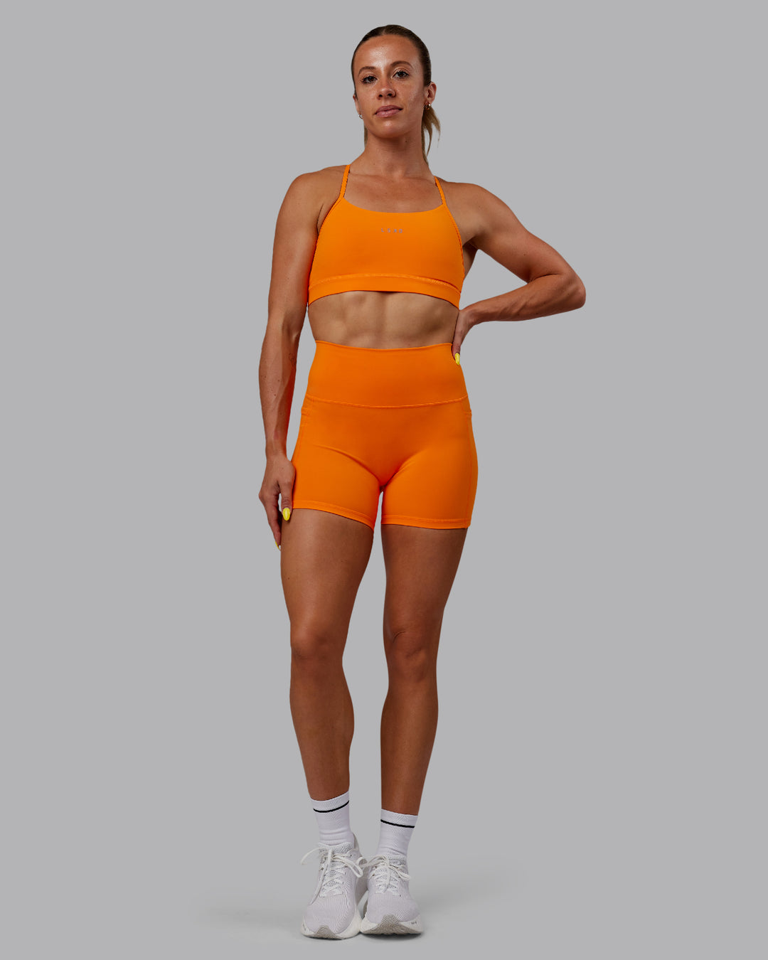 Woman wearing Fusion Ultra High-Rise 4&quot; Short Pockets - Vibrant Orange | Model:Bree | Size:S