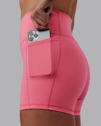 Woman wearing Fusion Ultra High-Rise 4" Short Pockets - Pink Lemonade | Model:Shae | Size:S