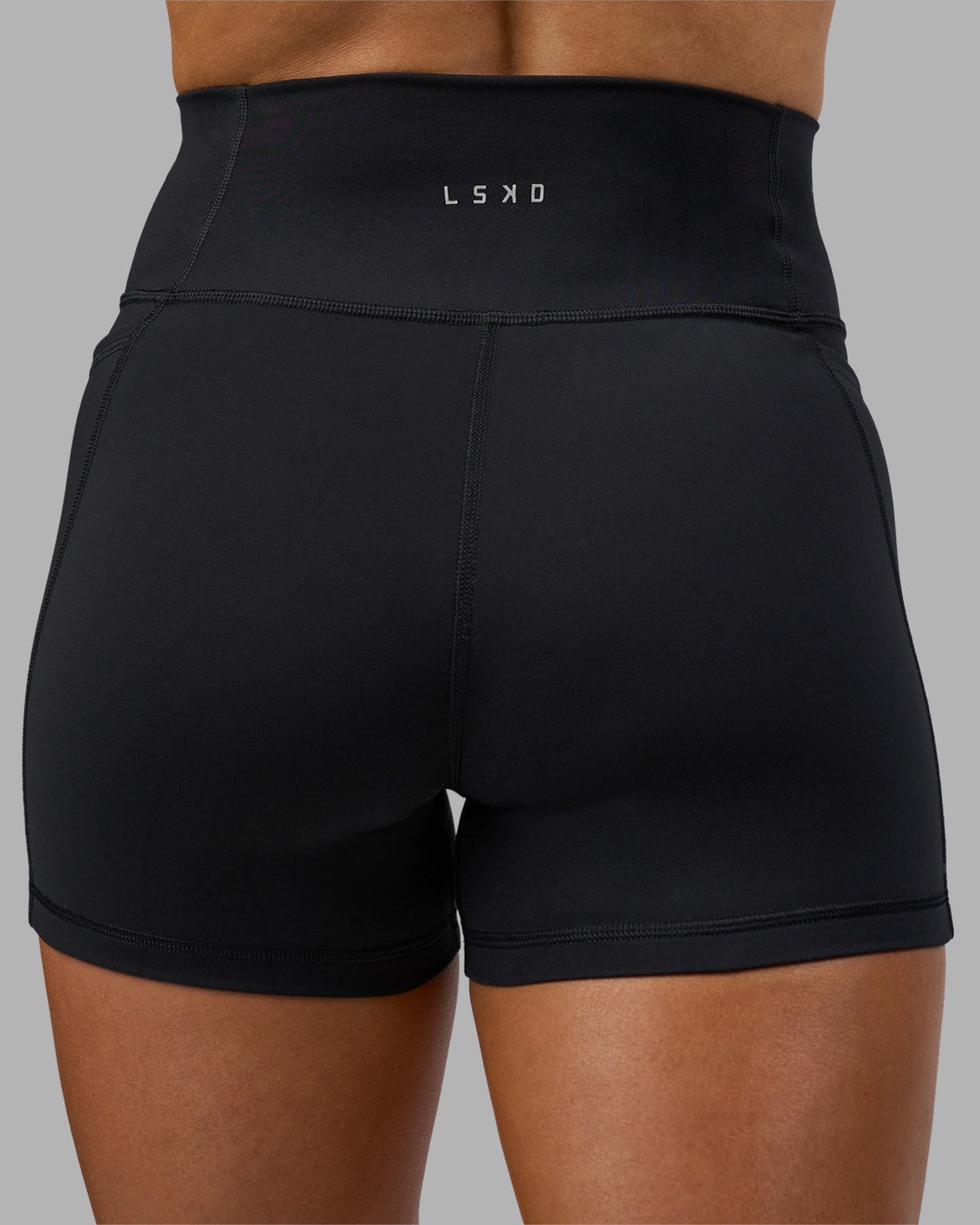 Woman wearing Fusion Ultra High-Rise 4&quot; Short Pockets - Black | Model:Georgia | Size:S