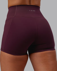 Woman wearing Fusion Ultra High-Rise 4" Short Pockets - Cherry Lacquer | Model:Lyss | Size:S