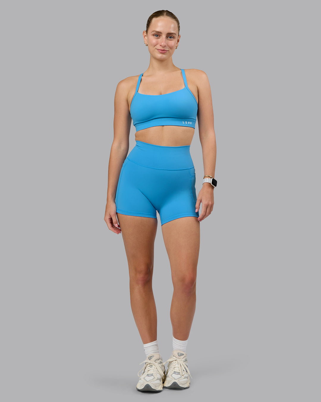 Woman wearing Fusion Ultra High-Rise 4&quot; Short Pockets - Azure Blue | Model:Lillie | Size:S
