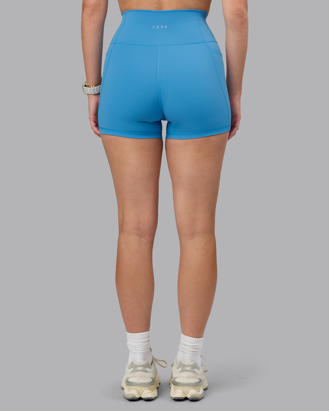 Woman wearing Fusion Ultra High-Rise 4&quot; Short Pockets - Azure Blue | Model:Lillie | Size:S