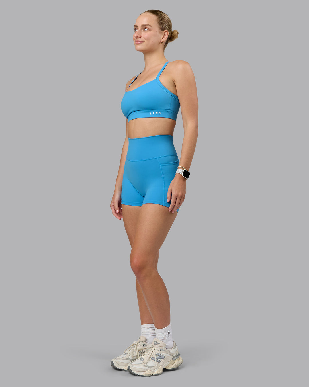 Woman wearing Fusion Ultra High-Rise 4&quot; Short Pockets - Azure Blue | Model:Lillie | Size:S