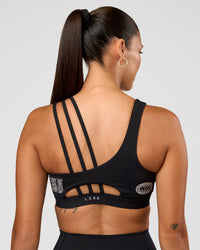 Woman wearing Galvanise Hype Graphic Sports Bra 2.0 - Black-Alloy | Model:Rhiley | Size:S