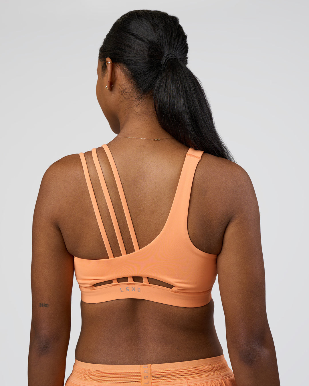Woman wearing Galvanise Splice Sports Bra - Cantaloupe | Model:Rica | Size:S