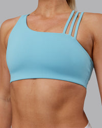 Woman wearing Galvanise Sports Bra 2.0 - Retro Blue | Set:true | Angle:closeup | Model:Hannah | Size:S