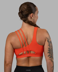 Woman wearing Galvanise Sports Bra 2.0 - Ultra Orange | Set:true | Angle:back | Model:Robyn | Size:S