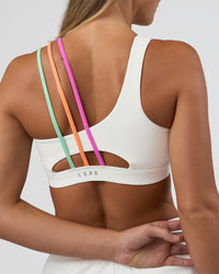 Woman wearing Galvanise Sports Bra 2.0 - Off White-Multi | Set:true | Angle:back | Model:Amity | Size:S