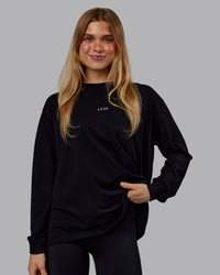 Woman wearing Go-To Long Sleeve FLXCotton Oversized Tee - Black-White | Model:Emilie | Size:S | Thumbnail Index: 0