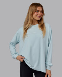 Woman wearing Go-To Long Sleeve FLXCotton Oversized Tee - Skyride-White | Model:Emilie | Size:S