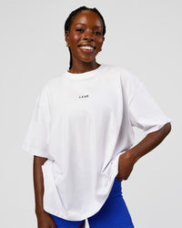 Woman wearing Go-To Run Club FLXCotton Oversized Tee - White-Electric Indigo | Model:Ellie | Size:S