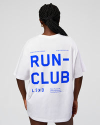 Woman wearing Go-To Run Club FLXCotton Oversized Tee - White-Electric Indigo | Model:Ellie | Size:S