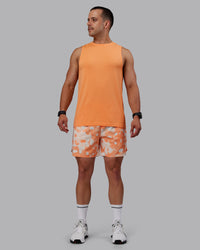Man wearing Grand Slam 6" Shorts in Wildflower Cantaloupe | Size:S