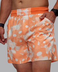 Man wearing Grand Slam 6" Shorts in Wildflower Cantaloupe | Size:S