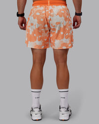 Man wearing Grand Slam 6" Shorts in Wildflower Cantaloupe | Size:S