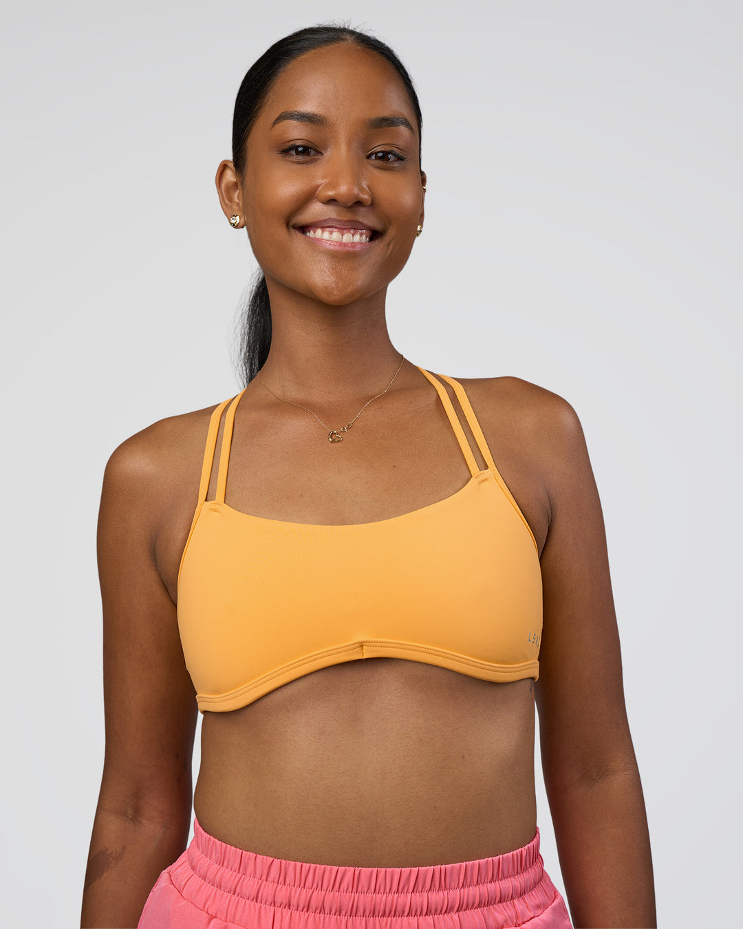 Woman wearing Interstellar Sports Bra - Warm Apricot | Model:Rica | Size:S