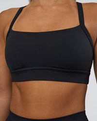 Woman wearing Momentum Sports Bra - Black | Model:Amity | Size:S