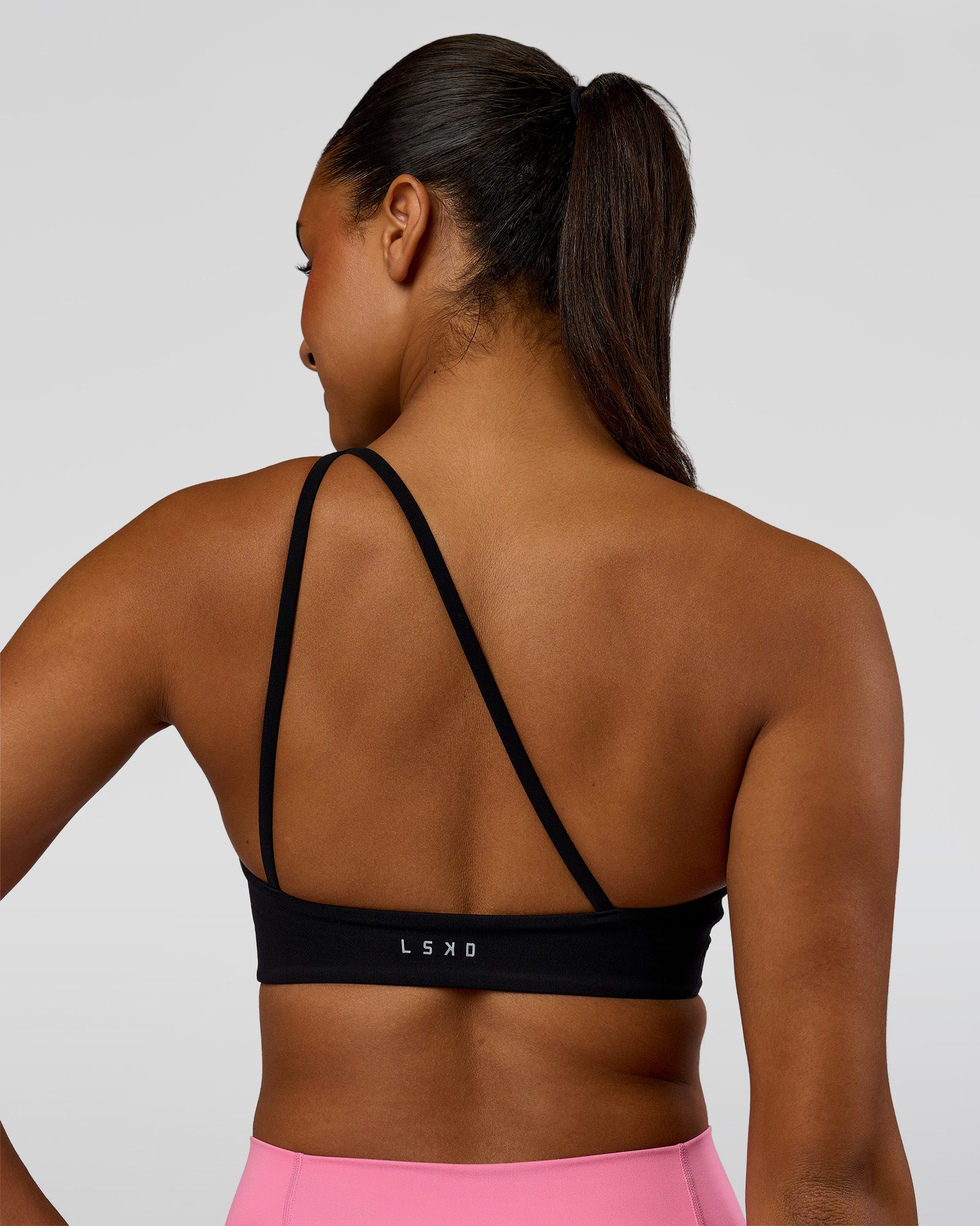 Woman wearing Muse Asymmetric Sports bra - Black | Model:Rosie | Size:S