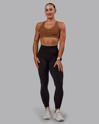 Woman wearing Nirvana Sports Bra in Caramel Agile Print | Size:S