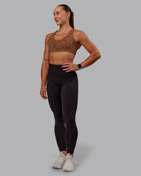 Woman wearing Nirvana Sports Bra in Caramel Agile Print | Size:S