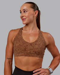 Woman wearing Nirvana Sports Bra in Caramel Agile Print | Size:S