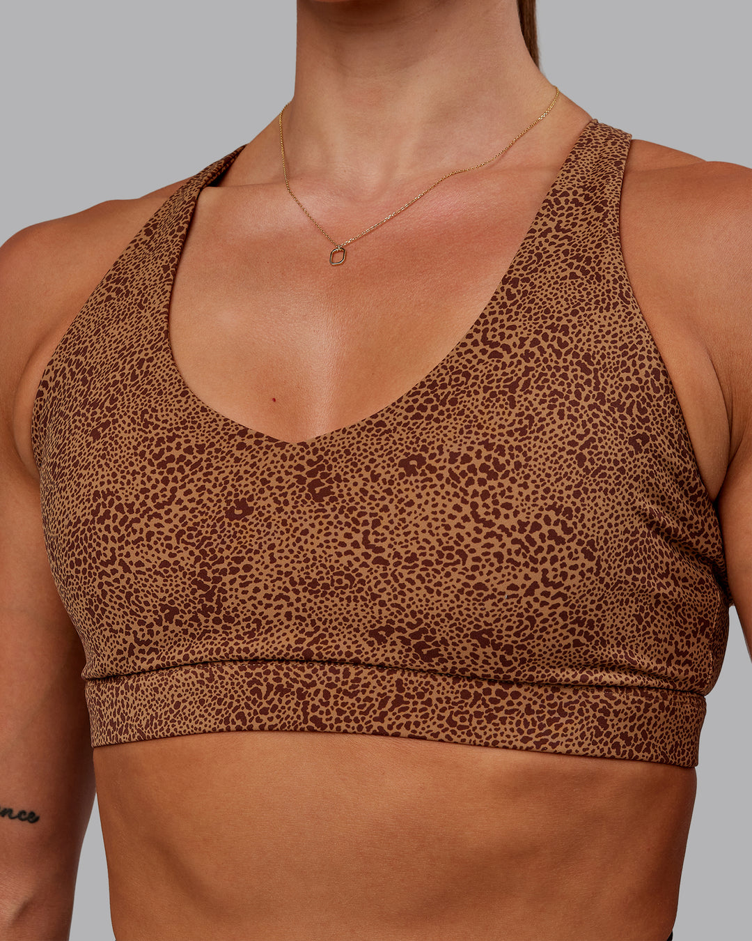 Woman wearing Nirvana Sports Bra in Caramel Agile Print | Size:S