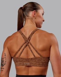 Woman wearing Nirvana Sports Bra in Caramel Agile Print | Size:S