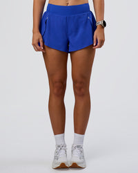 Woman wearing Pacer 3" Run Short - Electric Indigo | Model:Emelia | Size:S
