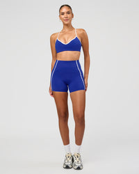 Woman wearing Power Ultra High-Rise 4" Short Pockets - Electric Indigo | Model:Rhiley | Size:S