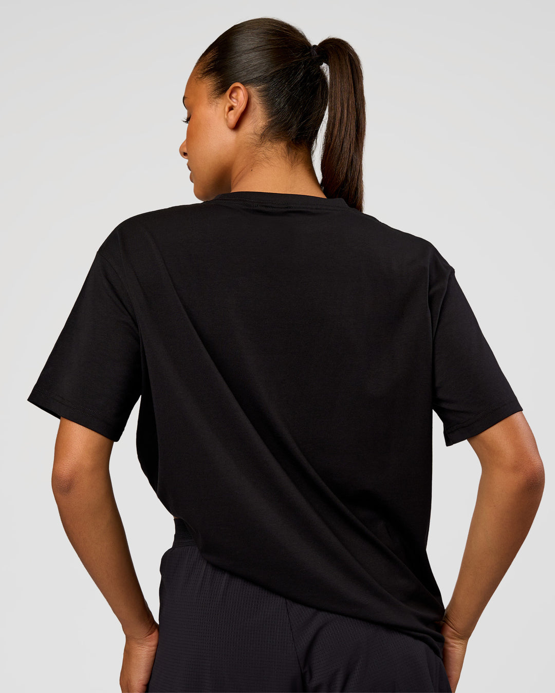 Woman wearing Pride Go-To FLXCotton Oversized Tee - Black | Model:Rosie | Size:S