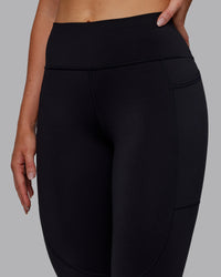 Woman wearing Rep Ultra High-Rise 7/8 Legging Pockets - Black-Retro Blue | Model:Paris | Size:S