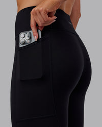 Woman wearing Rep Ultra High-Rise 7/8 Legging Pockets - Black-Retro Blue | Model:Paris | Size:S