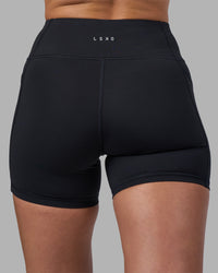 Woman wearing Rep Ultra High-Rise 4" Short Pockets - Black-Blue Atoll | Model:Sophie | Size:S