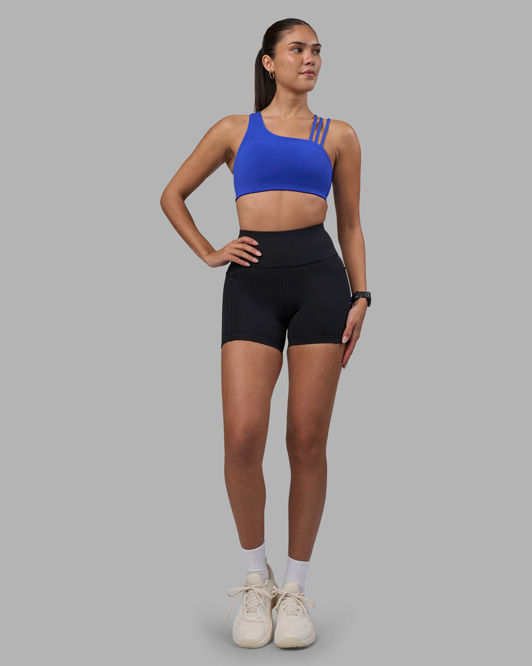 Woman wearing Rep Ultra High-Rise 4&quot; Short Pockets - Black-Power Cobalt | Model:Rhiley | Size:S