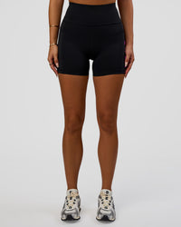 Woman wearing Rep Ultra High-Rise 4" Short Pockets - Black-Ultra Fuchsia | Model:Bianca | Size:S