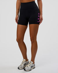 Woman wearing Rep Ultra High-Rise 4" Short Pockets - Black-Ultra Fuchsia | Model:Bianca | Size:S