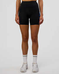 Woman wearing Rep Ultra High-Rise 6" Short Pockets - Black-Electric Indigo | Model:Evie | Size:S