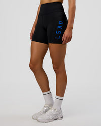 Woman wearing Rep Ultra High-Rise 6" Short Pockets - Black-Electric Indigo | Model:Evie | Size:S