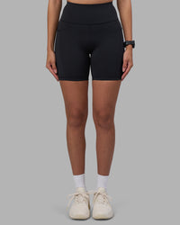 Woman wearing Rep Ultra High-Rise 6" Short Pockets - Black-Power Cobalt | Model:Rhiley | Size:S