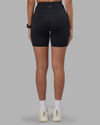 Woman wearing Rep Ultra High-Rise 6" Short Pockets - Black-Power Cobalt | Model:Rhiley | Size:S