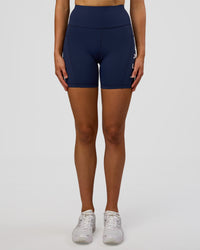 Woman wearing Rep Ultra High-Rise 6" Short Pockets - Future Navy-White | Model:Evie | Size:S
