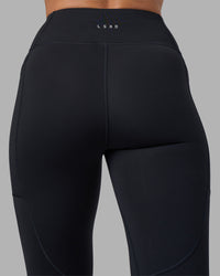 Woman wearing Rep Ultra High-Rise 7/8 Legging Pockets - Black-Blue Atoll | Model:Sophie | Size:S